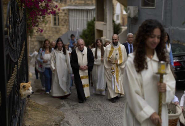 Christians take part in the traditional Palm Sunday procession in Quraye, near the southern port city of Sidon, Lebanon, Sunday, April 13, 2025. (AP Photo/Hassan Ammar)