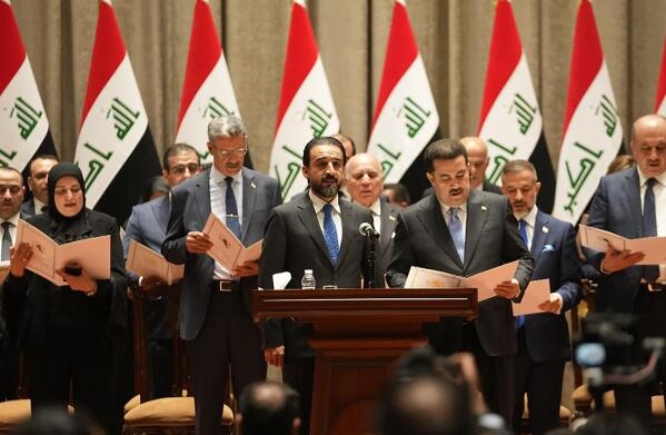 This photo provided by Iraqi Parliament Information Office shows ministers of the new Iraqi government being sworn in during the parliamentary session to vote on the new government in Baghdad, Iraq, Thursday, Oct. 27, 2022 (Iraqi Parliament Information Office via AP)