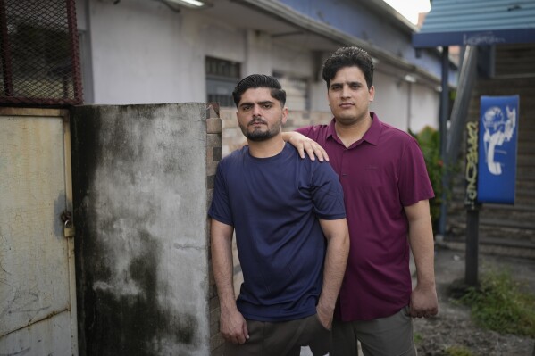 Samin Haider, left, a migrant from Pakistan, and his cousin Saqlain Sayed, pose for a portrait in Panama City, Monday, March 10, 2025, after being deported from the United States, detained for weeks in a Panamanian immigration camp, and released on a temporary humanitarian visa allowing a 30‑day stay. (AP Photo/Matias Delacroix)