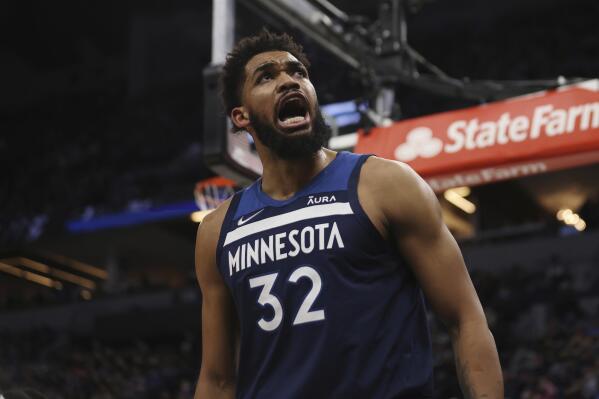 Minnesota Timberwolves center Karl-Anthony Towns (32) reacts after scoring a basket during the first half of an NBA basketball game against the Golden State Warriors, Sunday Jan. 16, 2022, in Minneapolis. (AP Photo/Stacy Bengs)