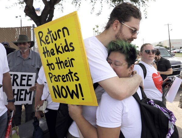 
              Diana Jung Kim, right, and Homer Carroll, both from Houston, hug during a protest outside the U.S. Border Patrol Central Processing Center Monday, June 25, 2018, in McAllen, Texas. (AP Photo/David J. Phillip)
            