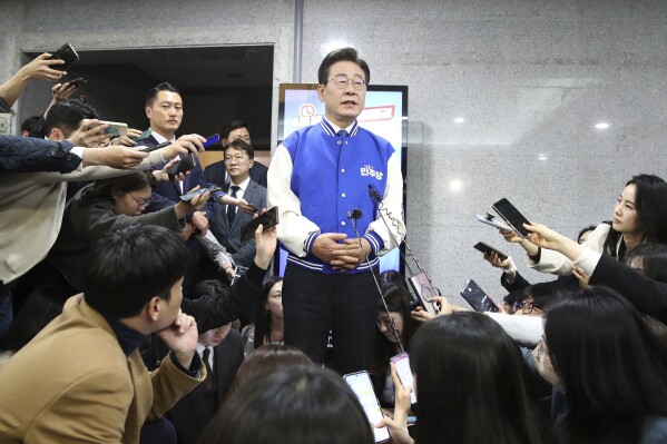 South Korea's main opposition Democratic Party (DP) leader Lee Jae-myung, center, speaks to reporters after watching TV broadcasting results of exit polls for the parliamentary election at the National Assembly on Wednesday, April 10, 2024 in Seoul, South Korea. (Chung Sung-Jun/Pool Photos via AP)