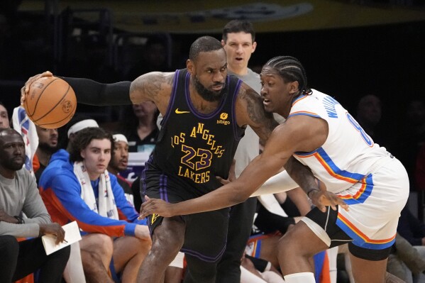 Oklahoma City Thunder forward Jalen Williams, right, reaches in on Los Angeles Lakers forward LeBron James during the first half of an NBA basketball game Monday, Jan. 15, 2024, in Los Angeles. (AP Photo/Mark J. Terrill)