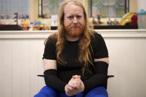 El luchador Liam Ledger, también conocido como Daemon Crowe, se sienta entre bastidores en la iglesia de San Pedro en Shipley antes de uno de los espectáculos mensuales de Kingdom Wrestling, el sábado 29 de marzo de 2025. (Foto AP/Jon Super)