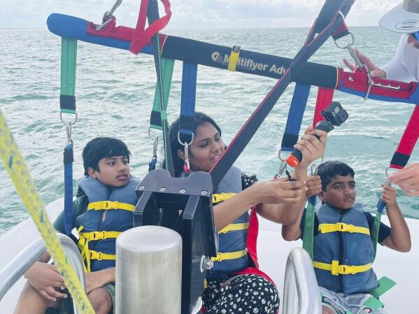 This photo released by the Alaparthi Family shows Supraja Alaparthi, 33, center, with her son and nephew as they prepare to parasail in the Florida Keys in June 2022. Alaparthi was killed after being dragged across the water while strapped into the parasail and slamming into a bridge. Attorneys representing the family have filed a wrongful death lawsuit against the captain, a crew member and a Florida resort company that owns the marina where the boat was based. (Alaparthi Family via AP)
