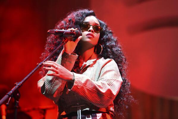 FILE - H.E.R. performs at the Spotify Best New Artist 2019 Party in Los Angeles on Feb. 7, 2019. The four-time Grammy winner will embark on her 19-city Back of My Mind tour in early April while separately joining Coldplay for their world tour as a supporting act later this month.(Photo by Phil McCarten/Invision/AP, File)