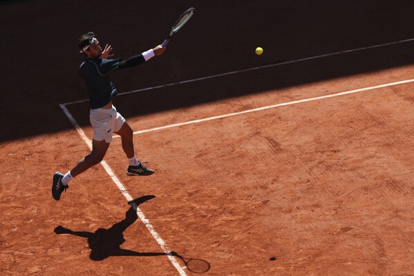 Italy's Lorenzo Musetti returns the ball to Argentina's Mariano Navone during their third round match of the French Tennis Open, at the Roland-Garros stadium, in Paris, Friday, May 30, 2025. (AP Photo/Lindsey Wasson)