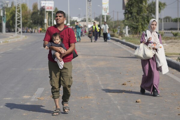 Palestinians flee the southern Gaza Strip on Salah al-Din street in Bureij on Sunday, Nov. 5, 2023. (AP Photo/Hatem Moussa)