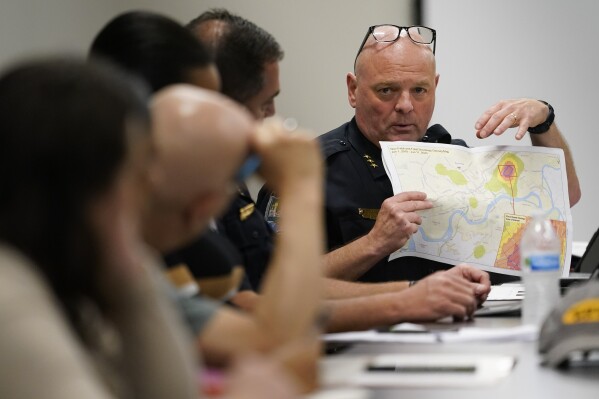 Knoxville Deputy Police Chief Tony Willis uses a map to show the concentration of gun violence crimes during a meeting of the Violence Reduction Leadership Committee on Thursday, Aug. 3, 2023, in Knoxville, Tenn. (AP Photo/George Walker IV)