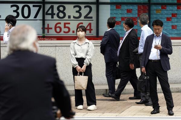 Some people watch at an electronic stock board showing Japan's Nikkei 225 index at a securities firm Thursday, May 25, 2023, in Tokyo. Shares were mostly lower in Asia on Thursday as worries about the U.S. economy and a possible default on U.S. government debt pulled Wall Street lower. (AP Photo/Eugene Hoshiko)
