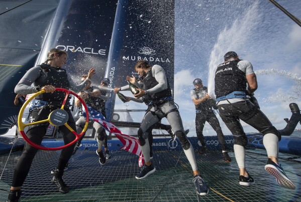 This photo provided by SailGP shows the USA SailGP team as they spray champagne to celebrate winning the Spain Sail Grand Prix in Cadiz, Spain, Sunday, Oct. 15, 2023. (Ricardo Pinto/SailGP via AP)