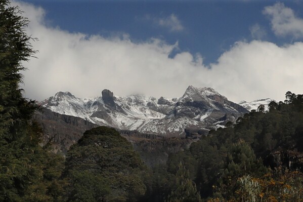 FILE - The Iztaccíhuatl volcano stands high near Santiago Xalitzintla, Mexico, May 3, 2019. Near the slopes of the Iztaccihuatl volcano, suspected illegal loggers shot and killed three forest rangers on patrol and wounded a fourth on Feb. 25, 2024, according to police in Puebla state. (AP Photo/Marco Ugarte, File)