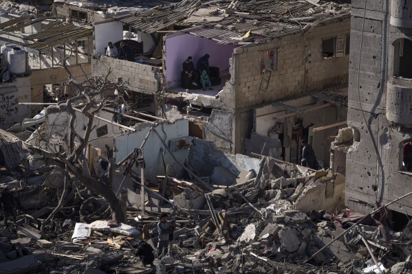 FILE - Palestinians look at the destruction after an Israeli strike on residential buildings and a mosque in Rafah, Gaza Strip, Thursday, Feb. 22, 2024. Israel and Hamas are inching toward a new deal that would free some of the roughly 130 hostages held in the Gaza Strip in exchange for a weeks-long pause in the war, now in its fifth month. A deal would bring some respite to desperate people in Gaza, who have borne a staggering toll in the war, as well as to the anguished families of hostages taken during Hamas' Oct. 7 attack that sparked the war. (AP Photo/Fatima Shbair, File)