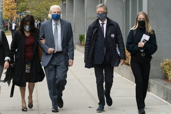 Toni Natalie, left, and India Oxenberg, right, arrive with their attorneys at Brooklyn federal court for a sentencing hearing for self-improvement guru Keith Raniere, Tuesday, Oct. 27, 2020 in New York. Raniere, whose organization NXIVM attracted millionaires and actresses among its adherents, is expected to be sentenced Tuesday on convictions that he turned some female followers into sex slaves branded with his initials. (AP Photo/Mark Lennihan)