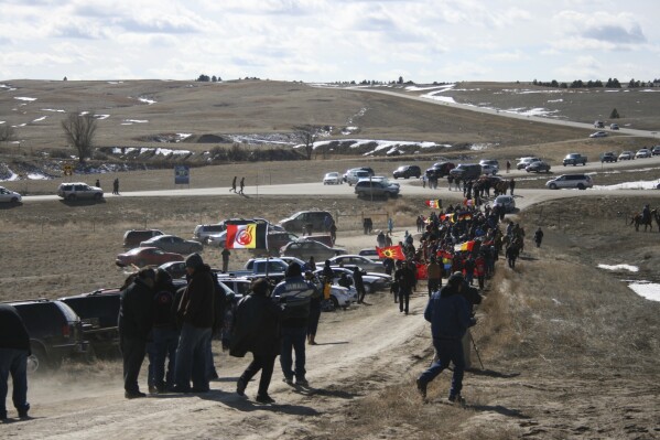FILE - Members of the American Indian Movement walk to the Wounded Knee Massacre Monument, Feb. 27, 2013 in Wounded Knee, S.D. A bill to preserve the site of the Wounded Knee massacre — one of the deadliest massacres in U.S. history — cleared the U.S. House of Representatives on Wednesday, Sept. 20, 2023. (AP Photo/Kristi Eaton, File)