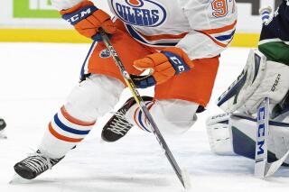 FILE - Edmonton Oilers center Connor McDavid (97) plays against the Vancouver Canucks during the third period of an NHL hockey game in Vancouver, British Columbia, in this Tuesday, Feb. 23, 2021, file photo. McDavid is back on the ice this week as he tries to build off a unanimous MVP season. (Jonathan Hayward/The Canadian Press via AP)