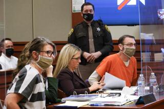 FILE - Jennifer Crumbley, left, and James Crumbley, right, the parents of Ethan Crumbley, a teenager accused of killing four students in a shooting at Oxford High School, appear in court for a preliminary examination on involuntary manslaughter charges in Rochester Hills, Mich. on Feb. 8, 2022. A judge has denied a motion to reduce bonds for the jailed parents of a Michigan teenager who is charged in a fatal shooting at his high school, Tuesday, April 19. (AP Photo/Paul Sancya, File)