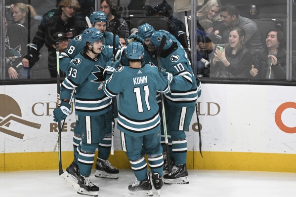San Jose Sharks celebrate a goal by defenseman Kyle Burroughs (4) against the Anaheim Ducks during the second period of an NHL hockey game, Saturday, Jan. 20, 2024, in San Jose, Calif. (AP Photo/Nic Coury)