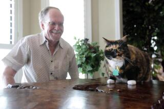 Fred Everitt of Tupelo, Miss., is all smiles after his cat, "Bandit", alerted him in the middle of the night that two men were trying to break into the back door of his home, July 29, 2022, in Tupelo, Miss. (Thomas Wells/Northeast Mississippi Daily Journal via AP)