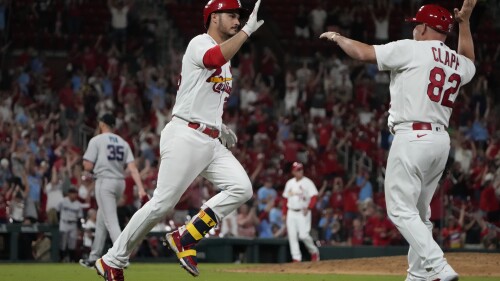 St. Louis Cardinals' Nolan Arenado is congratulated by first base coach Stubby Clapp (82) after hitting a walk-off home run off Miami Marlins relief pitcher A.J. Puk to defeat the Marlins 5-2 during the 10th inning of a baseball game Tuesday, July 18, 2023, in St. Louis. (AP Photo/Jeff Roberson)