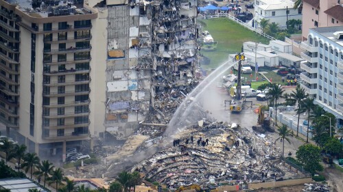 FILE - Rescue personnel work at the remains of the Champlain Towers South condo building, June 25, 2021, in Surfside, Fla. The swimming pool deck of the beachfront South Florida condominium where 98 people died when the building collapsed two years ago failed to comply with the original codes and standards, with many areas of severe strength deficiency, federal investigators said Thursday, June 15, 2023. (AP Photo/Gerald Herbert, File)