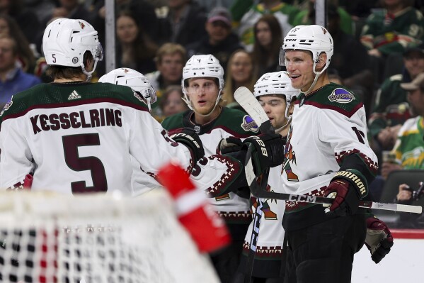 Arizona Coyotes center Nick Bjugstad, right, is congratulated for his goal against the Minnesota Wild during the second period of an NHL hockey game Tuesday, March 12, 2024, in St. Paul, Minn. (AP Photo/Matt Krohn)