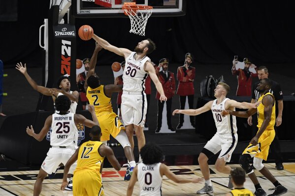 Virginia's Jay Huff (30) blocks a shot attempt by Towson's Zane Martin (2) in the second half of an NCAA college basketball game, Wednesday, Nov. 25, 2020, in Uncasville, Conn. (AP Photo/Jessica Hill)