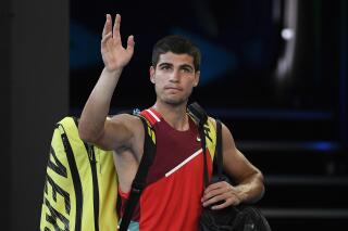 FILE- Carlos Alcaraz of Spain waves as he leaves Rod Laver Arena following his third round loss to Matteo Berrettini of Italy at the Australian Open tennis championships in Melbourne, Australia, on Jan. 21, 2022. Top-ranked Carlos Alcaraz pulled out of the Australian Open on Friday because of an injured right leg. (AP Photo/Andy Brownbill, File)