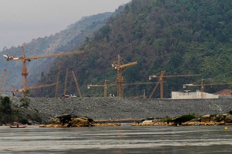 Fisherman catch fish in Mekong river in front of construction site of Luang Prabang dam in Luang Prabang, Laos, Sunday, Jan. 28, 2024. (AP Photo/Sakchai Lalit)