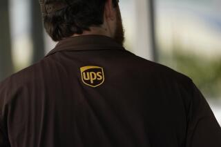 A UPS logo is on the shirt of a driver as he enters a United Parcel Service store with packages in Jackson, Miss., Monday, July 26, 2021.   Amazon, Chobani, UPS and more than 30 other companies have vowed to hire and train refugees fleeing Afghanistan for the U.S. The companies said Tuesday, Sept. 21,  that they want to help the tens of thousands of Afghan refugees coming to America to integrate into the economy.   (AP Photo/Rogelio V. Solis, File)
