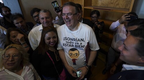 Former Mexican Foreign Minster Marcelo Ebrard, center, shares a laugh with supporters after a news conference at a library in Mexico City, Monday, June 12, 2023. The top diplomat has resigned his post to enter the primary race for the country's June 2, 2024, presidential election, and Mexico City Mayor Claudia Sheinbaum says she will do the same Friday. (AP Photo/Fernando Llano)
