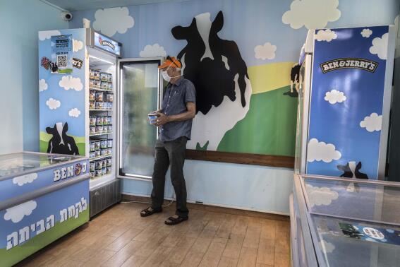 FILE - An Israeli shops at the Ben & Jerry's ice-cream factory in the Be'er Tuvia Industrial area on July 20, 2021. Ben & Jerry's board of directors on Tuesday, Nov. 15, 2022, rebuked the sale of products bearing any of the ice cream maker's insignia in West Bank settlements, the latest salvo in the Vermont-based company's feud with its corporate parent over ice cream sales in the territories. (AP Photo/Tsafrir Abayov, File)
