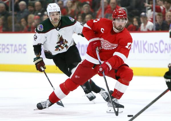 Detroit Red Wings center Dylan Larkin (71) takes the puck past Arizona Coyotes center Jack McBain (22) during the first period of an NHL hockey game Friday, Nov. 25, 2022, in Detroit. (AP Photo/Duane Burleson)