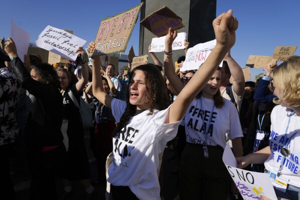 FILE - Demonstrators participate in a protest against fossil fuels at the COP27 U.N. Climate Summit, Nov. 18, 2022, in Sharm el-Sheikh, Egypt. As United Nations leaders, scientists and others called for an eventual elimination of coal, oil and natural gas, members of various delegations at the conference were connected to those industries. (AP Photo/Peter Dejong, File)