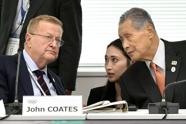 FILE - In this Wednesday, Oct. 30, 2010, file photo, International Olympic Committee member John Coates, left, talks with Yoshiro Mori, right, president of the 2020 Tokyo Olympics organizing committee, during a meeting to assess progress on the games of Tokyo 2020 Olympics, in Tokyo. The IOC abruptly announced two weeks ago it was moving next year’s Olympic marathon from Tokyo to the northern city of Sapporo. Mori already said that Tokyo will not pay if the move goes through. He acknowledged when the change was announced at Tokyo is already spending a humongous amount.(Kyodo News via AP, File)