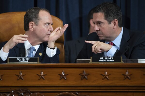 House Intelligence Committee Chairman Rep. Adam Schiff, D-Calif., left, talks with ranking member Rep. Devin Nunes, R-Calif., during a hearing of the House Intelligence Committee on Capitol Hill in Washington, Wednesday, Nov. 13, 2019, during the first public impeachment hearing of President Donald Trump's efforts to tie U.S. aid for Ukraine to investigations of his political opponents. (Saul Loeb/Pool Photo via AP)
