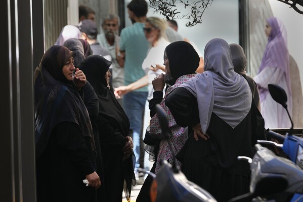 Families of victims who were injured Monday by their exploded handheld pagers, wait at the emergency entrance of the American University hospital, in Beirut, Lebanon, Wednesday, Sept. 18, 2024. (AP Photo/Hussein Malla)