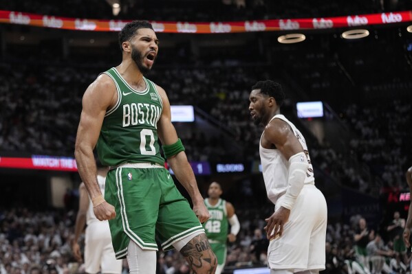 Boston Celtics forward Jayson Tatum (0) celebrates near Cleveland Cavaliers guard Donovan Mitchell, right, after a dunk during the second half of Game 3 of an NBA basketball second-round playoff series Saturday, May 11, 2024, in Cleveland. (AP Photo/Sue Ogrocki)