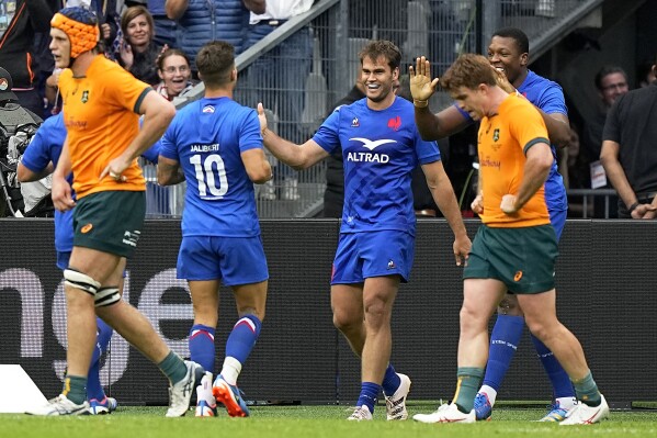 France's Damain Penau, centre, celebrates with teammates scoring a try during the International Rugby Union World Cup warm-up match between France and Australia at the Stade de France stadium in Saint Denis, outside Paris, Sunday, Aug. 27, 2023. (AP Photo/Michel Euler)