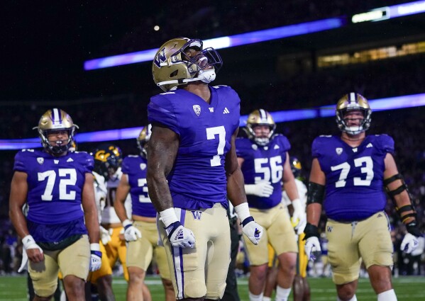 Washington running back Dillon Johnson (7) celebrates his touchdown against California as Parker Brailsford (72), Geirean Hatchett (56) and offensive lineman Roger Rosengarten (73) join him during the first half of an NCAA college football game Saturday, Sept. 23, 2023, in Seattle. (AP Photo/Lindsey Wasson)
