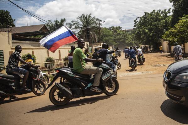 FILE - Supporters of Capt. Ibrahim Traore parade wave a Russian flag in the streets of Ouagadougou, Burkina Faso, Oct. 2, 2022. Just weeks after Burkina Faso's junta ousted hundreds of French troops, there are signs that the West African country could be moving even closer to Russia, including the mercenary outfit, the Wagner Group. (AP Photo/Sophie Garcia, File)