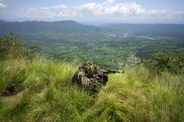 An Indian army soldier takes position during a mock drill along the highly militarized Line of Control that divides Kashmir region between India and Pakistan, in Nowshera sector about 127 kilometers (79 miles) from Jammu, India, Monday, Aug.12, 2024. (AP Photo/Channi Anand)