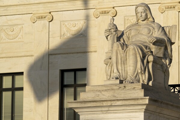 The United States flag casts a shadow on the Supreme Court building on Friday, April 21, 2023, in Washington. (AP Photo/Jacquelyn Martin)