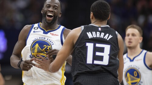 FILE - Golden State Warriors forward Draymond Green (23) smiles at Sacramento Kings forward Keegan Murray (13) during the second half of an NBA basketball game in Sacramento, Calif., April 7, 2023. Green got a new contract that'll pay him $100 million over four seasons with the Warriors. (AP Photo/José Luis Villegas, File)