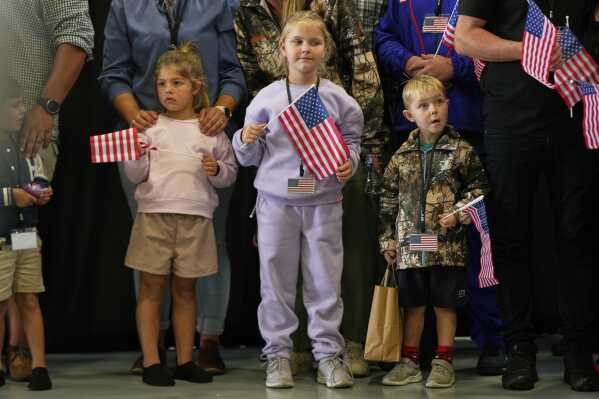 Young Afrikaner refugees from South Africa holding American flags arrive, Monday, May 12, 2025, at Dulles International Airport in Dulles, Va. (AP Photo/Julia Demaree Nikhinson)