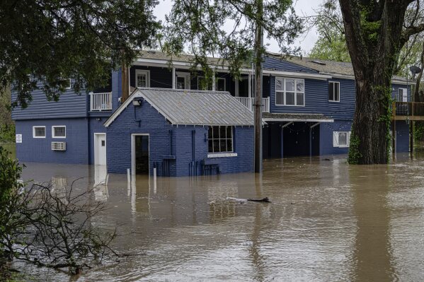 A flooded home is seen from the banks of the Ohio River on Saturday, April 5, 2025, in Louisville, Ky. (AP Photo/Jon Cherry)