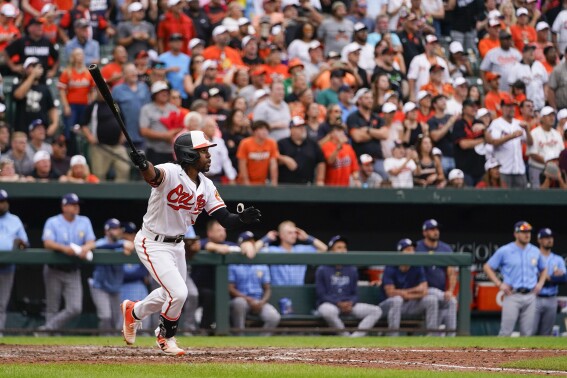 Baltimore Orioles' Cedric Mullins follows through as he connects for a sacrifice fly ball to score Adley Rutschman with the winning run in the 11th inning of a baseball game against the Tampa Bay Rays, Sunday, Sept. 17, 2023, in Baltimore. The Orioles won 5-4 in 11 innings. (AP Photo/Julio Cortez)
