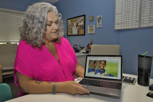 Longtime Florida social worker Connie Going looks at a computer screen with an image of her adopted son Davion in her adoptions office June 12, 2023, in St. Petersburg, Fla. Going said the Family-Match tool gives false hope to waiting parents by failing to deliver successful matches, and ultimately makes her job harder. (AP Photo/Chris O'Meara)