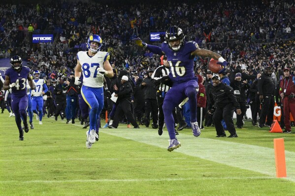 Baltimore Ravens punt returner Tylan Wallace (16) starts to celebrates as he returns a punt for a game-winning touchdown as Los Angeles Rams tight end Davis Allen (87) looks on during overtime of an NFL football game Sunday, Dec. 10, 2023, in Baltimore. The Ravens won 37-31. (AP Photo/Nick Wass)