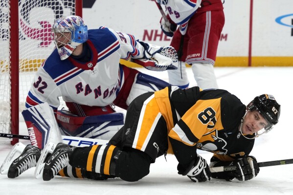 Pittsburgh Penguins' Sidney Crosby (87) picks himself up after a collision in front of New York Rangers goaltender Jonathan Quick (32) during the second period of an NHL hockey game in Pittsburgh, Wednesday, Nov. 22, 2023. (AP Photo/Gene J. Puskar)